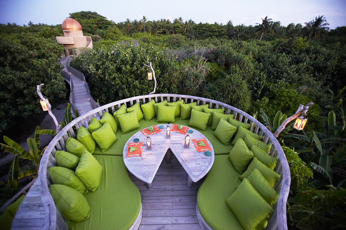 Star Table mit Blick über dicht bewachsende Vegetation zur Sternwarte in der Abenddämmerung auf Soneva Fushi Malediven