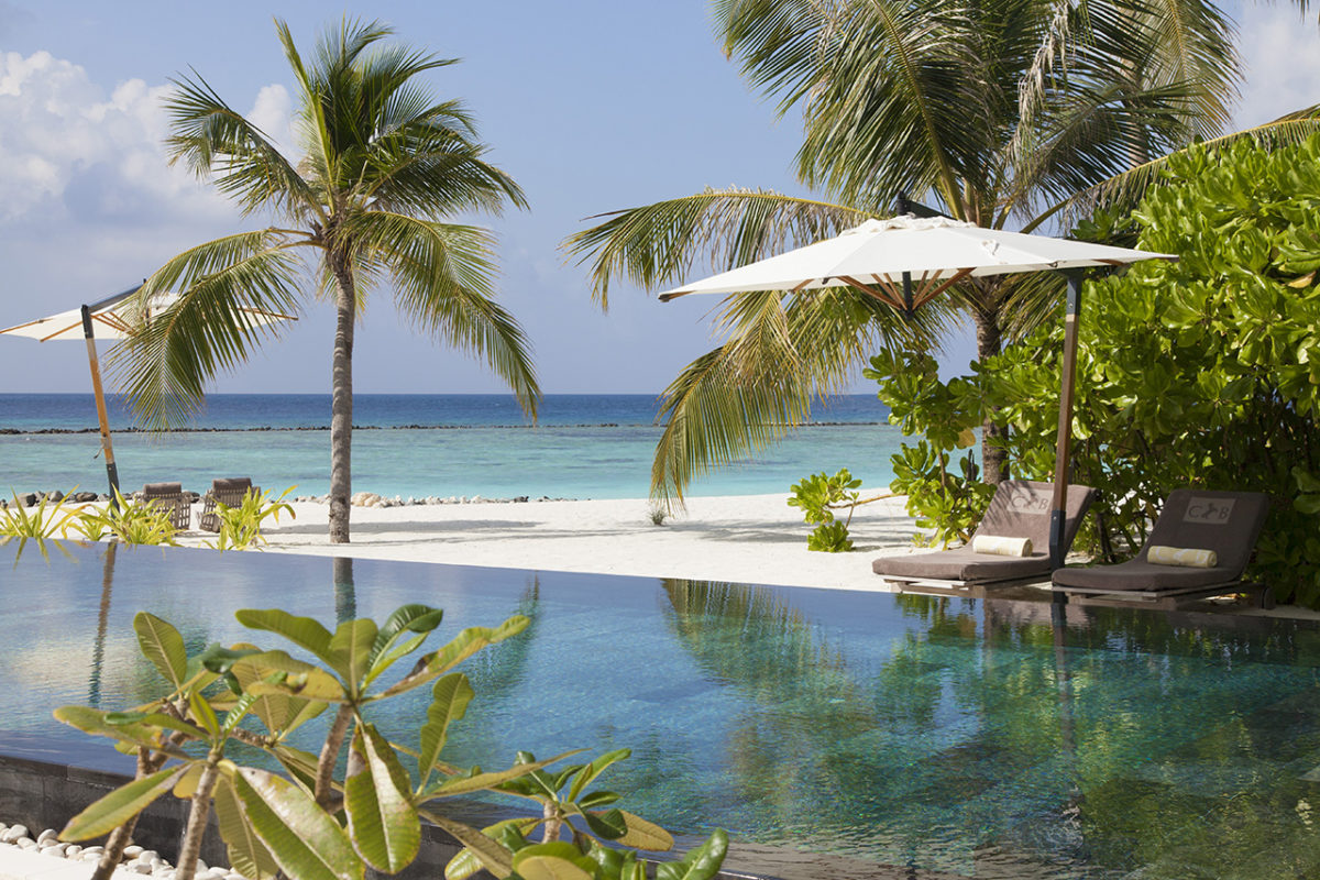 Blick von der privaten Terrasse der Island Villa vom Cheval Blanc Randheli Malediven über den Privatenpool zum Strand mit Palmen und dem türkisfarbenen Wasser
