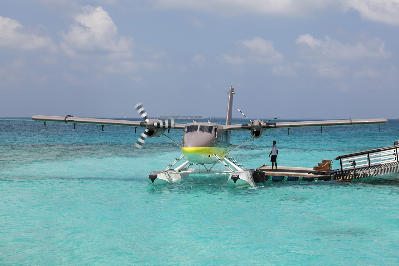 Hauseigenes Wasserflugzeug des uxusresorst Cheval Blanc Randheli in schickem Design am Jetty stehend in der türkisfarbenen Lagune des indischen Ozeans der Malediven