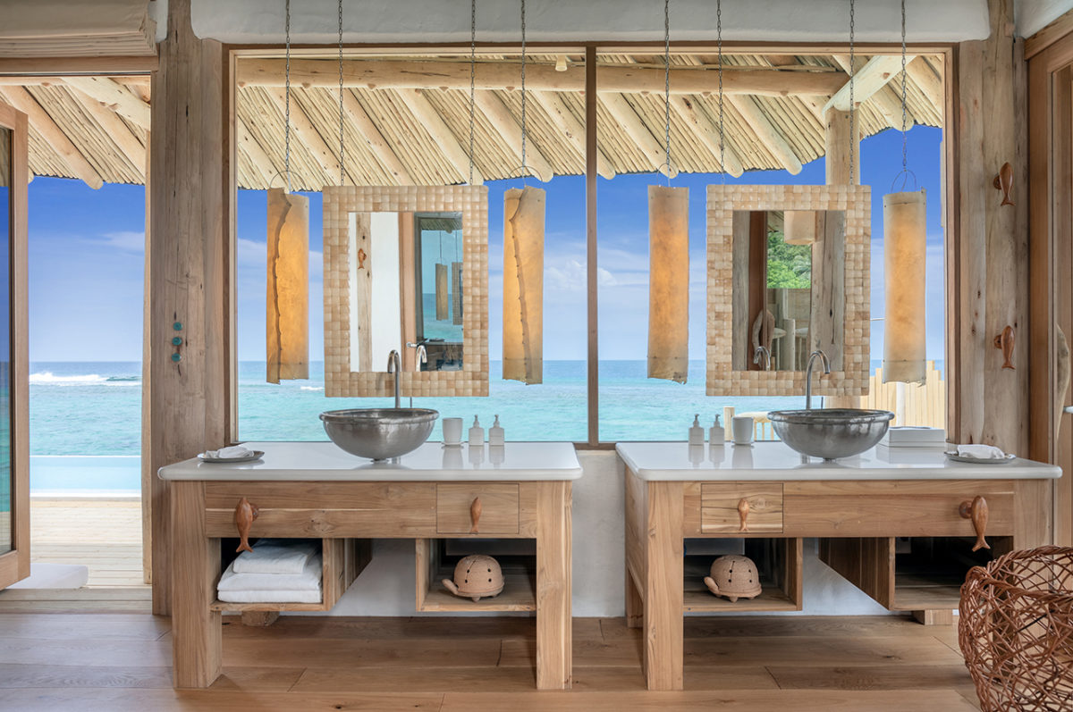 Outdoor Badezimmer des Luxus Eco Resorts Soneva Fushi mit Blick auf die türkisfarbene Lagune des indischen Ozeans der Malediven