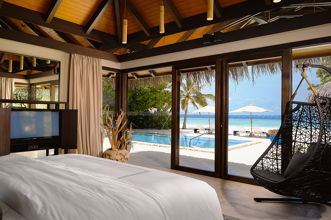 Blick aus dem Schlafzimmer über den privaten Pool bis zum schneeweißen Sandstrand an türkisfarbenen Meer der Malediven Insel Velaa Private Island