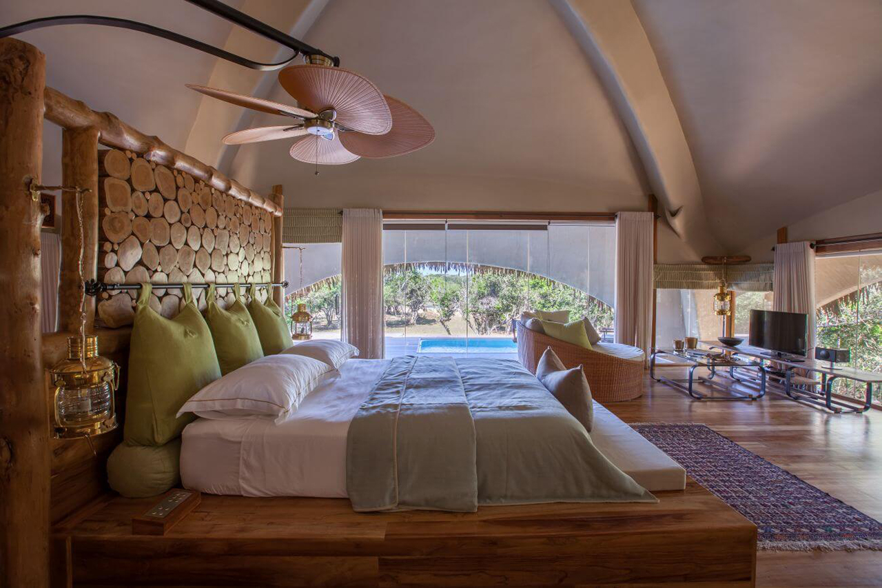 Schlafzimmer der Chena Huts Suite in Sri Lanka mit privatem Pool