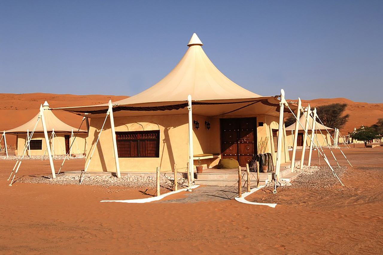Wüstencamp aus weißen individuellen Zelten für die Gäste inmitten der Wüste des Omans