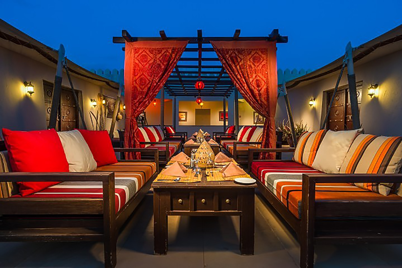 Dunes Restaurant in Abendstimmung mit romantischen Lampen und orientalischer Einrichtung inmitten der Wüste unter dem Sternenhimmel des Omans