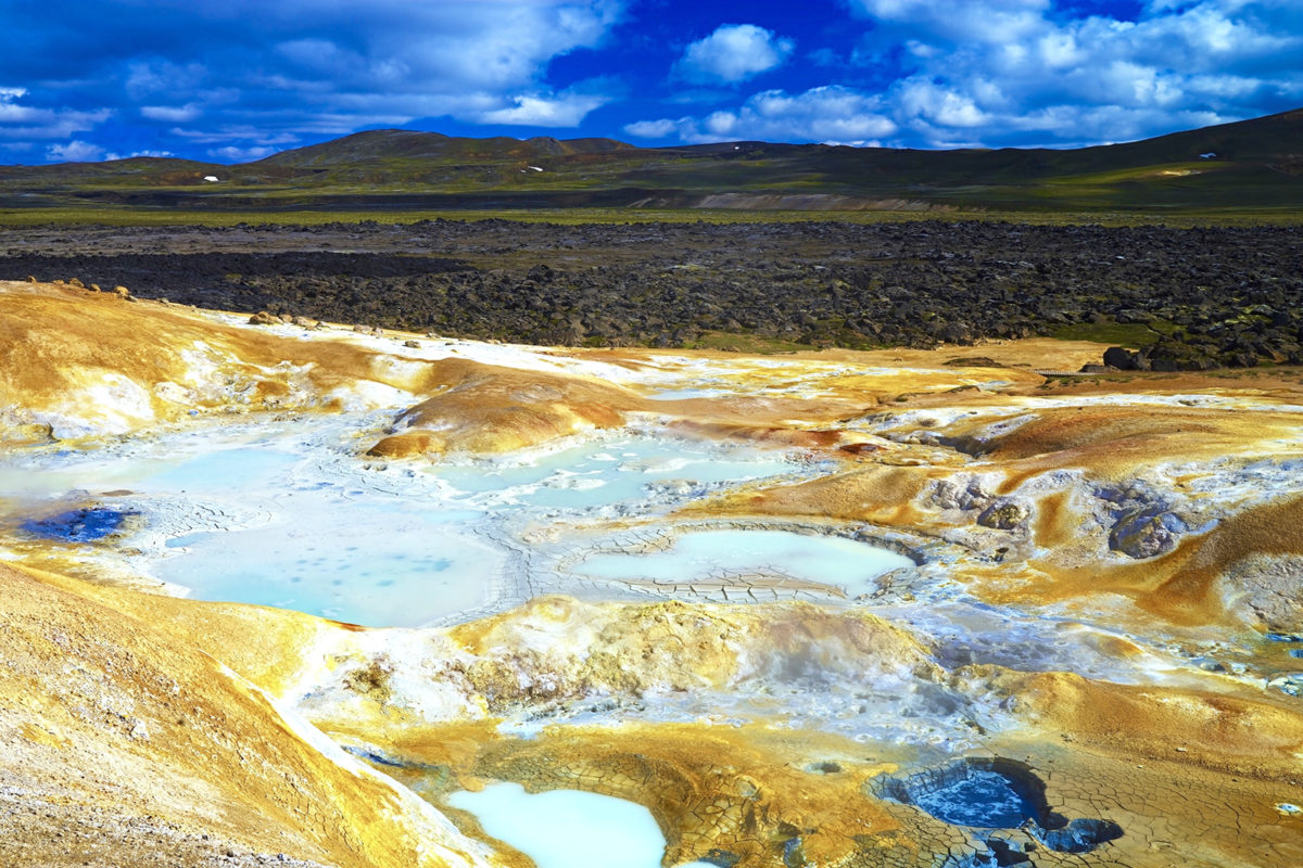 Vulkanlandschaft mit Schwefelfeldern auf Island im Sommer bei blauem Himmel und Sonnenschein