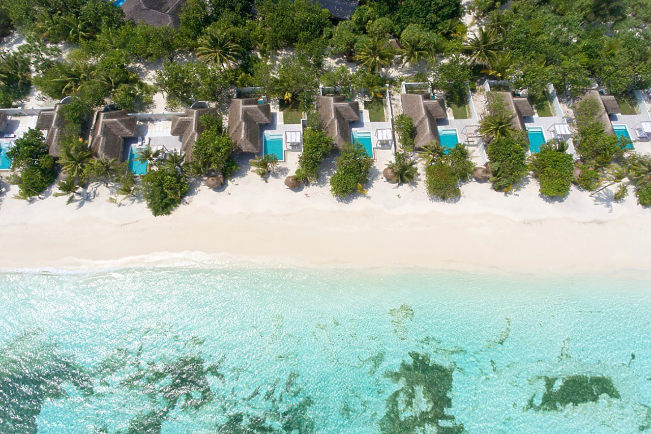 Strand Villen mit Pool aus der Vogelperspektive am schneeweißen Strand des Kanuhura Island Resorts auf den Malediven