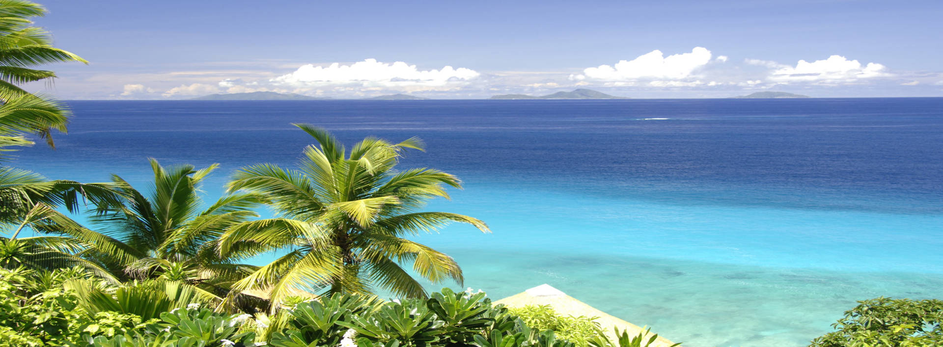 Blick vom höchsten Berg der Insel Fregate Island Private Seychellen auf das hellblaue Meer und die Palmen
