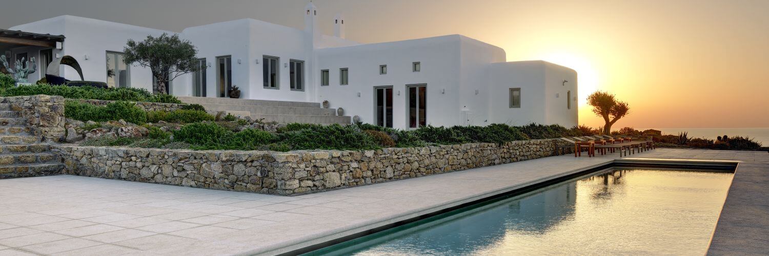Weiße Villa Delos auf Mykonos Griechenland mit privatem Pool im Sonnenuntergang