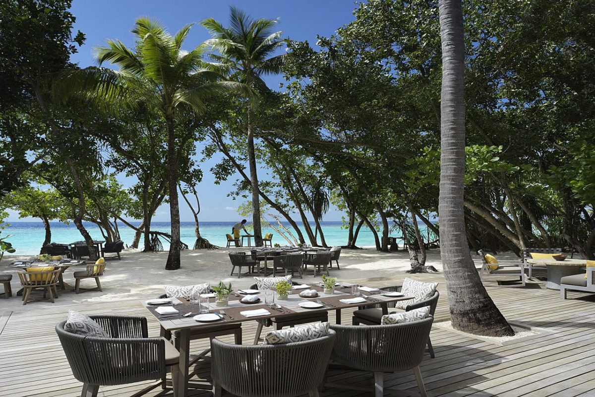 Restaurant des Luxusresorts Vakkaru Malediven unter Palmen im schneeweißen Sand