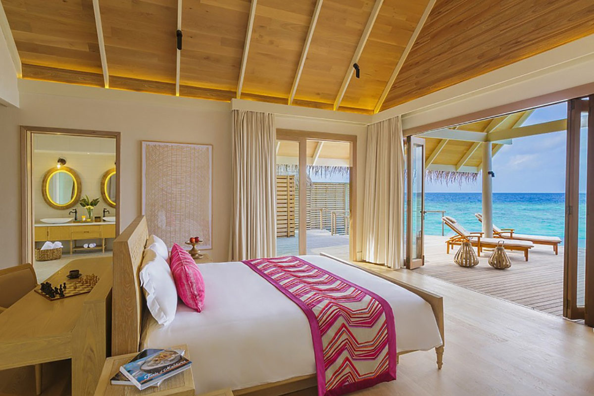 Schlafzimmer mit Blick auf das türkisfarbenen Wasser des indischen Ozeans der Luxusresort Insel Miladihoo auf den Malediven